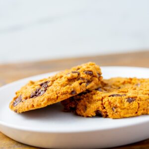 Two chocolate chip cookies on a plate. These cookies are available at Simply Baked Catering in Winchester, Ontario.