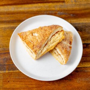 Two cinnamon sugar scones on a plate. These delicious scones are available at Simply Baked Catering Inc. in Winchester, Ontario.