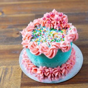 A regular cake with pink and blue icing and sprinkles at Simply Baked Catering Inc. in Winchester, Ontario.