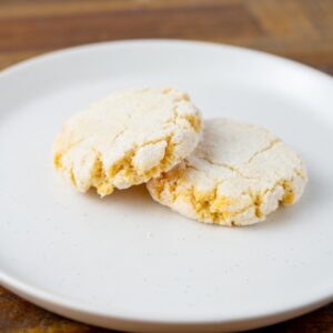 Two Amaretti cookies on a plate. These wheat-free Italian almond cookies are available at Simply Baked Catering Inc. in Winchester, Ontario.